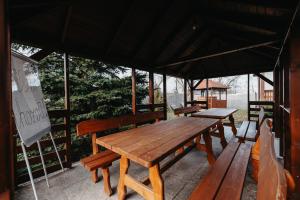 a wooden table and benches in a pavilion at Szárhegyi Vendégház in Lăzarea +25 photos