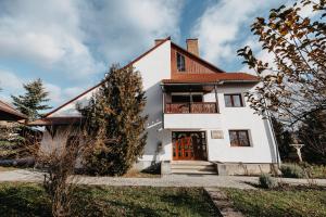 a white house with a red roof at Szárhegyi Vendégház in Lăzarea