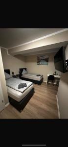 バート・ザルツフレンにあるCheckinn Hotelのベッド2台と薄型テレビ付きのベッドルーム