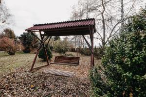 a bench in a park with a wooden canopy at Szárhegyi Vendégház in Lăzarea