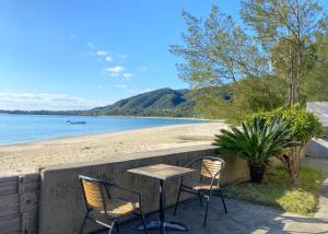 a table and chairs next to a beach at isola villa amami in Tatsugo