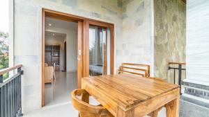 a wooden table and chairs on the porch of a house at Lavana Ubud in Ubud