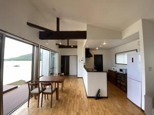 a kitchen and dining room with a table and chairs at isola villa amami in Tatsugo