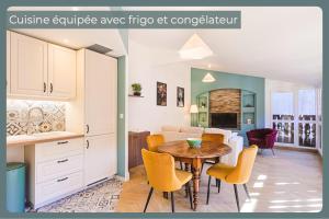 L'Allobroge - Charme & confort au cœur de Vienne في فيين: مطبخ وغرفة معيشة مع طاولة وكراسي