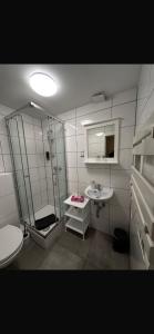 バート・ザルツフレンにあるCheckinn Hotelのシャワーと洗面台付きのバスルーム