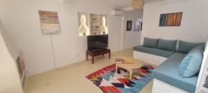 Una sala de estar con un sofá azul y una mesa. en Villa NAIM, en Marrakech