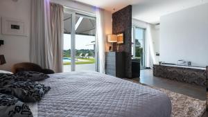 um quarto com uma cama grande e uma janela grande em Villa Atmosfere 8, Emma Villas em Colle Alto mais 35 fotografias