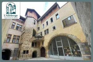 L'Allobroge - Charme & confort au cœur de Vienne في فيين: مبنى من الطوب كبير مع نافذة كبيرة