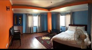 a bedroom with blue walls and a bed and a chair at Nargan hotel and appartment in Kathmandu