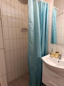 un bagno con tenda blu accanto a un lavandino di APARTY w Łomiankach a Łomianki