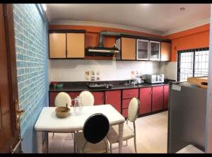 a kitchen with red cabinets and a white table and chairs at Nargan hotel and appartment in Kathmandu