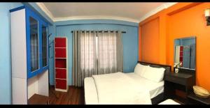 a bedroom with a white bed and colorful walls at Nargan hotel and appartment in Kathmandu
