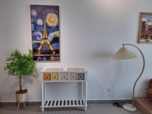 a table in a living room with a lamp and a painting at Amber Cove - Luxury Design By Luxpro Management - 6~7 pax in Melaka
