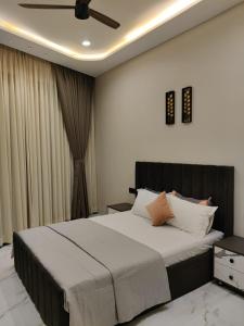 Un dormitorio con una cama grande con ventilador de techo. en Nuwara Eliya Karjat - 5BHK Villa, en Karjat