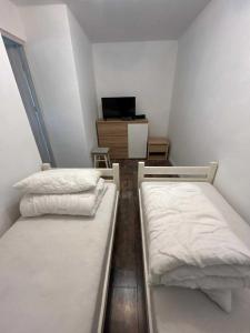 2 Betten in einem kleinen Zimmer mit einem TV in der Unterkunft Apartament Zborowskiego in Zakopane