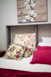 a bed with two pillows and a picture of flowers at Casa Flor do Campo in Celorico de Basto +50 photos