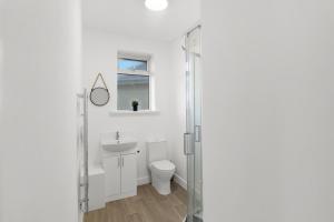 a white bathroom with a toilet and a sink at Perfect Booking 5 min Drive To Blyth Beach in Blythe