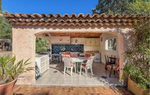 a patio with a table and chairs and a kitchen at Villa Avec Piscine 1 in Roquebrune-sur-Argens