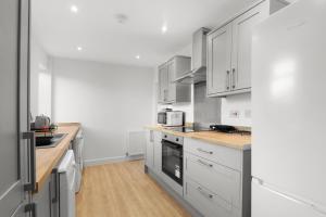 a kitchen with white cabinets and wooden counter tops at Perfect Booking 5 min Drive To Blyth Beach in Blythe +18 photos