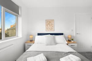 a white bedroom with a bed and a window at Perfect Booking 5 min Drive To Blyth Beach in Blythe