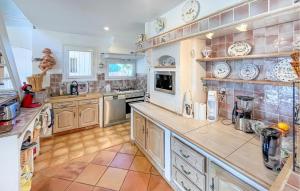 a large kitchen with white appliances and wooden cabinets at Villa Avec Piscine 1 in Roquebrune-sur-Argens