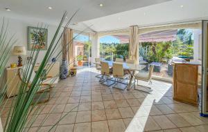 a dining room with a table and a large window at Villa Avec Piscine 1 in Roquebrune-sur-Argens