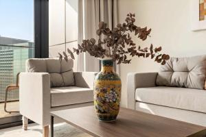 阿布扎比Silkhaus Luxury 3BDR Stay in Maryah Island的客厅里带花的花瓶