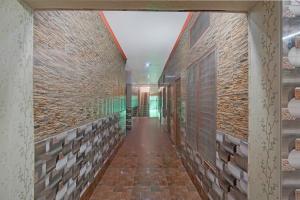 a hallway of a building with a brick wall at FabHotel Jyotish Bhawan in Ayodhya