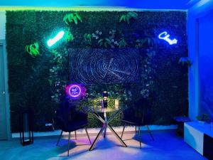 ein Zimmer mit einer grünen Wand mit einem Tisch und Stühlen in der Unterkunft Milano Bicocca Apartment & Rooms in Cinisello Balsamo