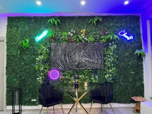 eine grüne Wand mit zwei Stühlen davor in der Unterkunft Milano Bicocca Apartment & Rooms in Cinisello Balsamo