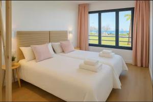 a bedroom with a large white bed with a window at Playa Sardinero - Little Homes 1-2-3-5 in Santander