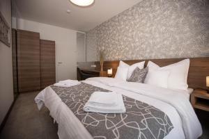 a bedroom with a large bed with towels on it at Hochnegger Apartments in Eibiswald