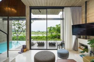 a living room with a view of a pool at The Xcape River Kwai in Kanchanaburi