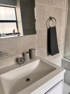 a bathroom with a white sink and a mirror at Cozy-corner in Gaborone
