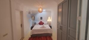 Dormitorio blanco con cama con almohada roja en Villa NAIM, en Marrakech
