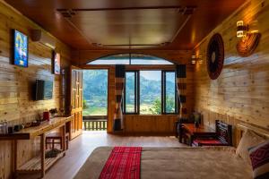 a bedroom with a large window and a bed in a room at Muong Hoa River View Hotel in Sa Pa
