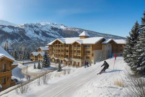 eine Person, die vor einer Skihütte Ski fährt in der Unterkunft SOWELL FAMILY Vars in Vars