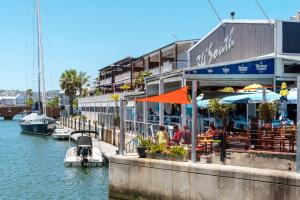 un ristorante vicino a un porto turistico con persone sedute ai tavoli di 307 Seahorse - 1 Bedroom Premium Unit with Parking a Knysna
