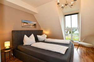 a bed with two pillows on it in a room at Frisch renoviertes FH Südblick am Meer in Breege, Meerblick von allen drei Etagen, Terrasse, Balkon, Sauna und Parkplatz in Breege