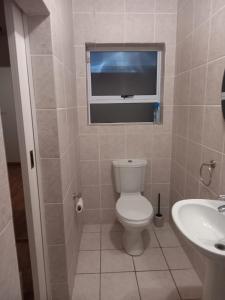 een badkamer met toilet, wastafel en raam bij Muize at Sea in Marina da Gama +13 foto's