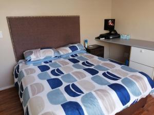 een slaapkamer met een bed met een blauw en wit dekbed bij Muize at Sea in Marina da Gama