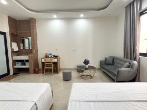 a hotel room with two beds and a couch at Ha Noi Smile Home in Ðình Loan