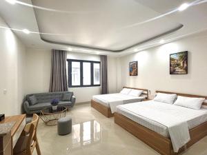 a hotel room with two beds and a couch at Ha Noi Smile Home in Ðình Loan