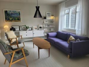 a living room with a blue couch and a chair at Rustic, Scandinavian house close to Reykjavik in Garðabær