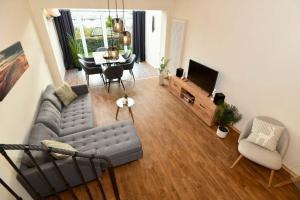a living room with a couch and a tv and a table at Frisch renoviertes FH Südblick am Meer in Breege, Meerblick von allen drei Etagen, Terrasse, Balkon, Sauna und Parkplatz in Breege