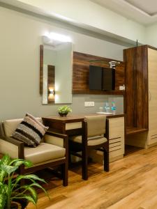 a living room with a table and chairs and a television at Hotel Ameya in Mumbai