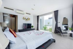 a bedroom with a large white bed and a television at Villa D3 Private - In Great Location Front Of The Sea in Vung Tau
