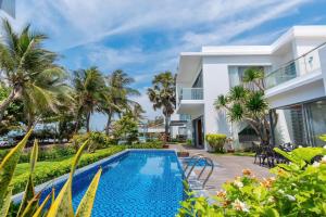 a villa with a swimming pool in front of a house at Villa D3 Private - In Great Location Front Of The Sea in Vung Tau