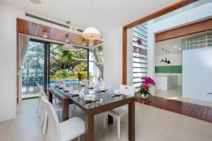a dining room with a long table and white chairs at Villa D3 Private - In Great Location Front Of The Sea in Vung Tau