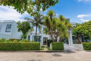 a white building with palm trees in front of it at Villa D3 Private - In Great Location Front Of The Sea in Vung Tau